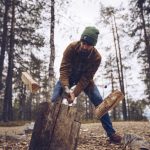 Young man chopping woog in the forest